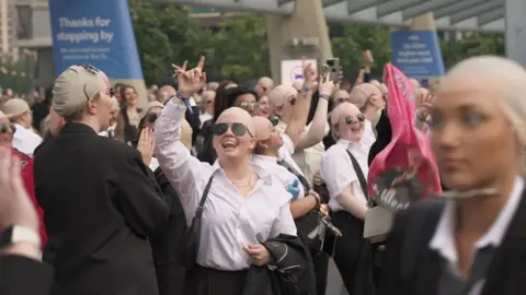 BBC Fans dressed as Pitbull in sunglasses, bald caps and suits pictured outside the O2 Arena in London