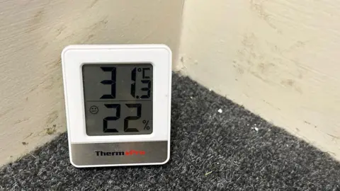 A thermometer showing that the corridor in Fatima's corridor was 31C (88F)