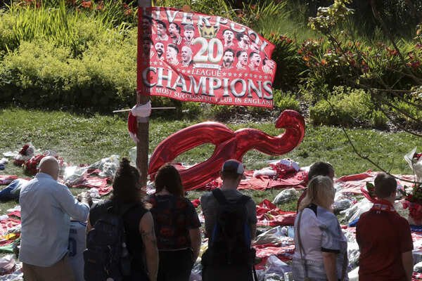 Football fans stand near tributes in memory of Liverpool player Diogo Jota at Anfield. (AP) Britain Liverpool Jota Soccer
